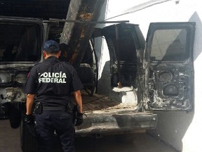 In this Sept. 17, 2016 photo released by Mexico Federal Police, an officer stands next to a van outfitted with a 10-foot (3-metre) air cannon in Agua Prieta, Mexico, along the border with Douglas, Arizona. According to federal police, it was used to shoot projectiles into the U.S. and the van was reported stolen from the city of Hermosillo in the Mexican state of Sonora over the summer. a U.S. Border Patrol spokesman said that the most common common use for this sort of device is lobbying marijuana packages over the border fence. (AP Photo/Policia Federal Preventiva)