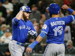 Toronto Blue Jays' Russell Martin, left, is greeted at the plate by Jose Bautista, right, after Bautista scored on Martin's two-run home run in the fourth inning of a baseball game against the Seattle Mariners, Tuesday, Sept. 20, 2016, in Seattle. (AP Photo/Ted S. Warren)