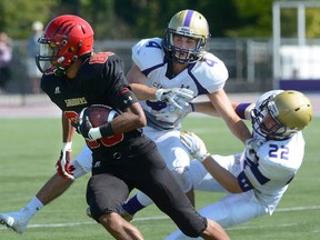 Central Secondary defenders Griffin Campbell, centre, and Quinn Currado, right, collide while trying to tackle Saunders receiver Noel Franklin during the opening game in the United Way tournament played at TD Waterhouse Stadium at Tuesday September 20, 2016. (MORRIS LAMONT, The London Free Press)