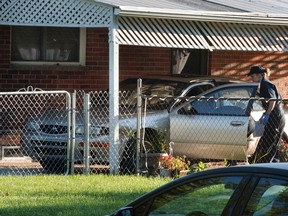 Dearborn Heights police photograph a vehicle in the covered driveway of 4431 Hipp street in Detroit in Detroit, in Dearborn Heights Mich., on Wednesday, Sept. 21, 2016. A man is in custody after his two children were asphyxiated, his wife’s two older children were fatally shot and his wife was shot and slashed at their suburban Detroit home, police said Wednesday. (Daniel Mears/The Detroit News via AP )