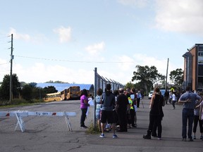 Students wait to board buses during evacuation procedures at Charlottetown Rural High School in Charlottetown, P.E.I., on Wednesday, September 21, 2016. RCMP say someone faxed a bomb threat against schools on Prince Edward Island this morning. (THE CANADIAN PRESS/Nathan Rochford)