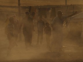 Iraqi's walk through a displacement camp for those caught-up in the fighting in and around the city of Mosul on June 26, 2014 in Khazair, Iraq. (Photo by Spencer Platt/Getty Images)