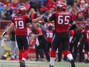 Calgary Stampeders Bo Levi Mitchell and Dan Federkeil celebrate after a touchdown by Jerome Messam against the Ottawa Redblacks during CFL football in Calgary, Alta., on Saturday, September 17, 2016.