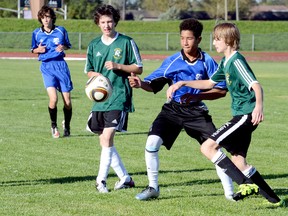 Braeden Chalwell, of the Timmins High & Vocational School Blues, plays the ball between Roland Michener Secondary School Rebels defenders Ryan Tayler, left, and Hans Parnell during a NEOAA Central Division Boys Soccer exhibition game at the Timmins Regional Athletics and Soccer Complex on Tuesday. The Blues scored a 6-0 victory in their final preseason tuneup. The two sides will open the regular season against each other at RMSS on Monday.  THOMAS PERRY/THE DAILY PRESS