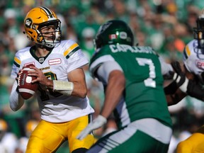 Edmonton Eskimos quarterback Mike Reilly, left, drops back to pass the ball during first half CFL action against the Saskatchewan Roughriders, in Regina on Sunday, September 18, 2016.