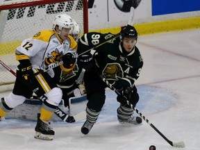 Victor Mete of the London Knights clears the puck away from Knights goaltender Tyler Johnson with Sarnia Sting winger Jacob Stos nearby during the Ontario Hockey League game at Progressive Auto Sales Arena on Wednesday September 21, 2016 in Sarnia, Ont. Sarnia and London played the first of six head-to-head games this season. (Terry Bridge/Sarnia Observer/Postmedia Network)