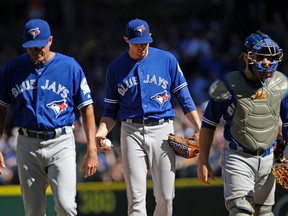 Toronto Blue Jays starting pitcher Aaron Sanchez (centre) waits as teammates head off the mound after having a conference against the Seattle Mariners in the third inning of a baseball game Sept. 21, 2016, in Seattle. (ELAINE THOMPSON/AP)