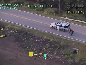 In this photo made from a Sept. 16, 2016 police video, Terence Crutcher, left, with his arms up is pursued by police officers as he walks next to his stalled SUV moments before he was shot and killed by one of the officers in Tulsa, Okla. When it comes to charging an officer, legal experts say, the most important determination isn't whether the officer was actually in danger in hindsight. It's whether the officer reasonably believed in his or her own mind that they or fellow officers were in danger at the split second they choose to shoot. There's no clear, standard formula investigators can rely on to answer the question of whether an officer's belief that he or she's in peril is reasonable, a former federal prosecutor in Chicago said. (Tulsa Police Department via AP)