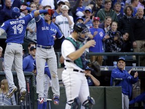 Toronto Blue Jays' Jose Bautista is congratulated by Troy Tulowitzki as Seattle Mariners catcher Jesus Sucre looks away after Bautista's home run in the ninth inning of a baseball game Wednesday, Sept. 21, 2016, in Seattle. (AP Photo/Elaine Thompson)
