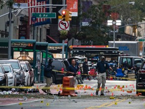 In this Sept. 18, 2016 file photo, crime scene investigators work the scene of a pressure cooker bomb explosion in Manhattan's Chelsea neighborhood, in New York. Although the device that wounded over two dozen people on the street went off in front of an apartment building for the blind, none of the building's residents were hurt in the blast. (AP Photo/Craig Ruttle, File)