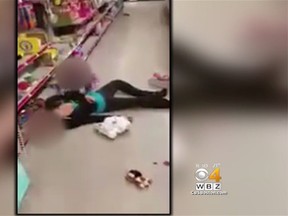 A clip of a toddler attempting to wake her mother up in a Dollar Store after she appears to have overdosed is pictured in this CBS Boston screengrab. (CBS Boston/YouTube screengrab)