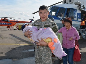 In this photo dated Wednesday, Sept. 21, 2016, provided by the Tuva Emergency Ministry Situations press service, an unidentified special force soldier carries a 3-year old boy rescued after going missing for three days in an undisclosed location in the Russian Siberian region of Tuva. The boy, who was under care of his grandmother, reportedly vanished in the woods after having followed a puppy. (Tuva Emergency Situations Ministry press service photo via AP)