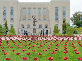 Four guards of the 4th Battalion of the Royal Canadian Regiment in London stand at arms by the Goderich Cenotaph during the unveiling ceremony of the 551 ceramic poppies that represent the lives Huron County lost during the First World War. (Darryl Coote/The Goderich Signal Star)