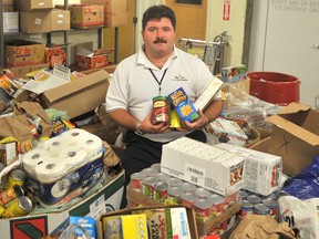 Myles Vanni, executive director of the Inn of the Good Shepherd, is pictured in October, 2011 showing off the results of the agency's Thanksgiving Food Drive. This year the Inn's is aiming to raise 40,000 pounds of food in its annual donation drive. (Observer file photo)