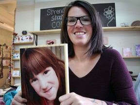 Natalie George with a photo of her daughter, Ryann, who stuck herself with a needle she found in McBurney Park in Kingston. (Steph Crosier/The Whig-Standard)