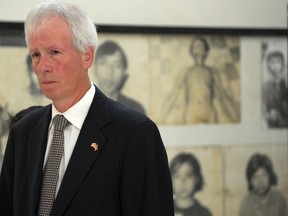Foreign Minister Stephane Dion (L) looks at portraits of victims of the Khmer Rouge displayed during his visit at the Tuol Sleng genocide museum in Phnom Penh on September 2, 2016. (TANG CHHIN SOTHY/AFP/Getty Images)