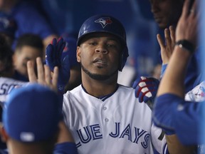 Blue Jays' Edwin Encarnacion  is congratulated by teammates in the dugout after scoring a run in the first inning against the New York Yankees on Friday night at the Rogers Centre. (GETTY IMAGES/PHOTO)