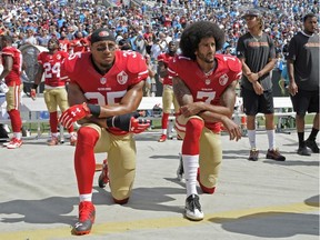 49ers' Colin Kaepernick (7) and Eric Reid (35) kneel during the national anthem before an NFL game against the Panthers in Charlotte, N.C., on Sunday, Sept. 18, 2016. (Mike McCarn/AP Photo)