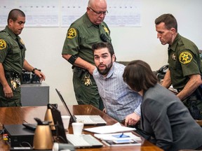 Orange County Sheriff deputies sit Daniel Wozniak for his sentencing in Superior Court, Friday, Sept. 23, 2016 in Santa Ana, Calif. Daniel Patrick Wozniak, who killed Samuel Herr and Julie Kibuishi as part of a plot to steal money to pay for his wedding and honeymoon was sentenced to death Friday. (Mark Rightmire/The Orange County Register via AP)