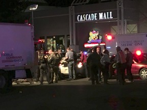 Law enforcement officers stand in front of the Macy's store at the Cascade Mall in Burlington, Wash., where several people were fatally shot, Friday, Sept. 23, 2016. Authorities in Washington State say several people have been killed during a shooting at the mall north of Seattle. At least one gunman is believed to be still at large. (Rick Lund/The Seattle Times via AP)