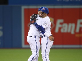 Devon Travis #29 of the Toronto Blue Jays celebrates their victory with Ryan Goins #17 during MLB game action against the New York Yankees on September 23, 2016 at Rogers Centre in Toronto, Ontario, Canada. (Photo by Tom Szczerbowski/Getty Images)