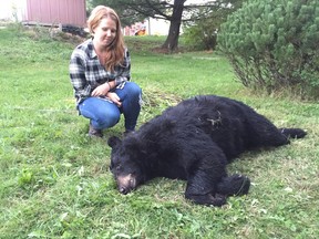 Katie Kulmala with a dead bear in her neighbour’s backyard. The two women believe the bear was shot and have had no luck finding someone to move it. (Mary Katherine Keown/The Sudbury Star)