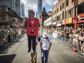 A member of the Democrats Abroad parade group holds up an anti-Donald Trump sign during the annual Toronto Pride Parade in Toronto, Sunday July 3, 2016. THE CANADIAN PRESS/Mark Blinch