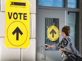 A woman enters Maple High School in Vaughan, Ont., to cast her vote in the federal election on Monday, Oct. 19, 2015. The summer political season is one usually spent far away from Ottawa, but this year a group of MPs has been gathering for meetings of the special committee on electoral reform to hear from expert witnesses on how and whether they should, change the way Canadians cast their federal election ballots. THE CANADIAN PRESS/Peter Power