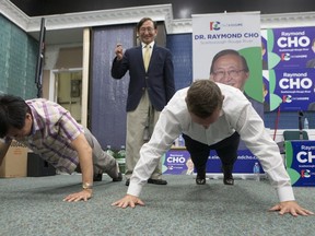 Ontario PC Leader Patrick Brown, right, participates in a 22 pus- up challenge alongside Raymond Cho Jr. as Raymond Cho, centre, counts them out at a campaign victory party to celebrate Cho's election in the Scarborough-Rouge River byelection in Toronto, on Thursday, September 1 , 2016. THE CANADIAN PRESS/Chris Young