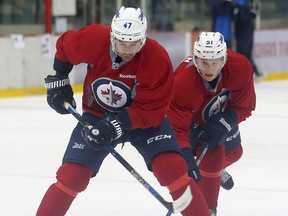 Winnipeg Jets defencemen Brian Strait (l) and Luke Green fight for the puck during NHL hockey practice in Winnipeg, Man. Saturday September 24, 2016.