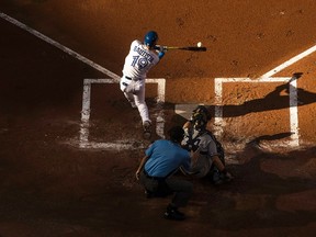 Blue Jays batter Jose Bautista hits a double against the Yankees during second inning MLB action in Toronto on Saturday Sept. 24, 2016. Bautista later hit a game-winning three-run home run in the eighth inning. (Mark Blinch/The Canadian Press)