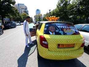 Uljan Kolgjegja, 37, an Albanian taxi driver, shows his taxi which he has covered with pictures of U.S. Republican candidate Donald Trump and U.S. flags, in the Albanian capital, Tirana, Monday, Sept. 26, 2016. Uljan Kolgjegja said Monday he was prompted to decorate his taxi with pictures of the Republican candidate after Albania’s Prime Minister Edi Rama said Trump could be "a real threat to Albanian-American ties." (AP Photo/Hektor Pustina)