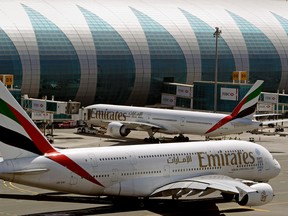 In this May 8, 2014 file photo, Emirates passenger planes are in use at Dubai airport in United Arab Emirates. Dubai Airports said Monday it plans to add 10 more A380 gates with air bridges at Dubai International Airport's Concourse C. That will leave the airport with a world record 47 gates designed for the aircraft. (AP Photo/Kamran Jebreili, File)