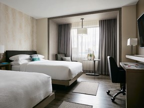 This undated image provided by Marriott shows one of the hotel company's redesigned "modern guest rooms." The redesigned rooms include desks, hardwood floors, benches to place luggage on and walk-in showers with handheld sprayers rather than tubs. The redesign has been completed in more than 10,000 rooms at 25 hotels with another 25 hotels in the pipeline this year. (Rick Lew/Marriott Hotels via AP)