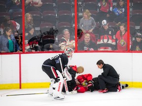 Trainers attend to Clarke MacArthur after he was hurt on Sept. 25. (Ashley Fraser, Postmedia Network)
