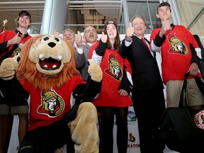 Belleville's director of recreation, culture and community cervices Mark Fluhrer, Mayor Taso Christopher, Senators owner Eugene Melnyk pose for a photo with local students after donating some children's hockey equipment.
The donation was held as part of a press conference announcing the Ottawa Senators are relocating their AHL team to Belleville where they will become the Belleville Senators, at the Quinte Sports and Wellness Centre, Monday September 26, 2016 in Belleville, Ont. 

Emily Mountney-Lessard/Belleville Intelligencer/Postmedia Network