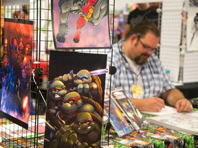 Canadian cartoon artist Dan Hammond works on a drawing at his booth at the London Comic Con at the Western Fair Progress building in London. (MIKE HENSEN, The London Free Press)