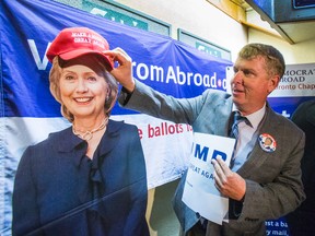 Toronto Sun Columnist Joe Warmington gives a cutout of Hillary Clinton a Donald Trump hat at a debate night event hosted by Democrats Abroad Canada at Pauper's Pub at Bloor and Bathurst Sts. on Sept. 26, 2016. (Ernest Doroszuk/Toronto Sun)