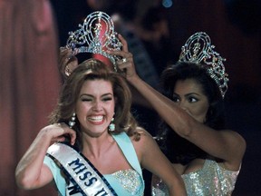 In this May 17, 1996, file photo, the new Miss Universe Alicia Machado of Venezuela reacts as she is crowned by the 1995 winner Chelsi Smith at the Miss Universe competition in Las Vegas. Machado became a topic of conversation during the first presidential debate between Republican nominee Donald Trump and Democratic candidate Hillary Clinton on Sept. 27, 2016. (AP Photo/Eric Draper, File)