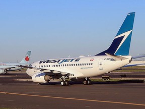 A WestJet flight and an Air Canada flight cross paths on a runway at the Lester B. Pearson airport as photographed from an airplane on August 28, 2012 in Toronto, Canada. (Photo by Bruce Bennett/Getty Images)