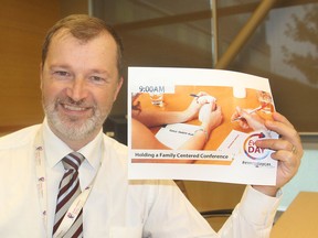 Steve Woodman, executive director of Family and Children's Services for Frontenac, Lennox and Addington, holds promotional items for an online project in which in-house stories about the agency and its work are told. (Michael Lea/The Whig-Standard)