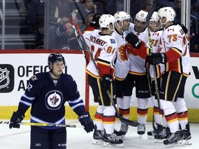 Calgary Flames' Garnet Hathaway (64), Lance Bouma (17), Freddie Hamilton (25), Brett Kulak (61) and Keegan Kanzig (73) celebrate after Hamilton scored against the Winnipeg Jets during second period pre-season NHL hockey in Winnipeg, Tuesday, September 27, 2016. THE CANADIAN PRESS/Trevor Hagan