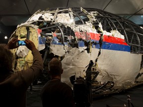 In this Tuesday, Oct. 13, 2015 file photo, journalists take images of part of the reconstructed forward section of the fuselage after the presentation of the Dutch Safety Board's final report into what caused Malaysia Airlines Flight 17 to break up high over Eastern Ukraine last year, killing all 298 people on board, during a press conference in Gilze-Rijen, central Netherlands. (AP Photo/Peter Dejong, File)