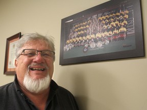 Don Dean, in Kingston on Tuesday, stands next to a photo of the world championship-winning Kingston Grenadier Drum and Bugle Corps from 2004. He was recently inducted into the World Drum Corps Hall of Fame for his work with the local corps. (Michael Lea/The Whig-Standard)