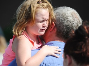 Lilly Chapman, 8, cries after being reunited with her father, John Chapman at Oakdale Baptist Church on Wednesday, Sept. 28, 2016, in Townville, S.C. Students were evacuated to the church following a shooting at Townville Elementary School. A teenager opened fire at a South Carolina elementary school on Wednesday. (AP Photo/Rainier Ehrhardt)