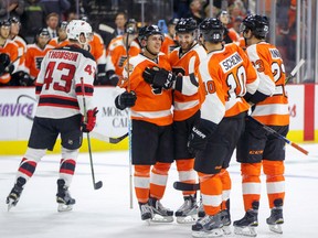 Philadelphia Flyers' Travis Konecny, center left, celebrates his deflected goal with teammates as New Jersey Devils' Ben Thomson, left, skates back to his bench during the second period of a preseason NHL hockey game, Wednesday, Sept. 28, 2016, in Allentown, Pa. (AP Photo/Chris Szagola)