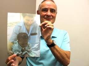 John Barnfield, president of Rayjon Share Care, holds up a photo taken on his first trip to Haiti. He has now been travelling to the developing country for 30 years as part of the community development organization he founded with Ray Wyrzykowski. A 30th anniversary celebration is planned for Oct. 14 at the Sarnia Riding Club. (Barbara Simpson/Sarnia Observer)