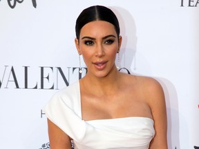 In this Sunday, May 22, 2016 file photo, Kim Kardashian poses for photographers as she arrives for the premiere of Verdi’s ‘’La Traviata’’ at the Rome Opera House, in Rome. Serial celebrity prankster Vitalii Sediuk has struck again, this time at Paris Fashion Week, targeting Kim Kardashian’s derriere as she was entering the L'Avenue restaurant. Kardashian’s makeup artist caught the Wednesday, Sept. 28, 2016 incident in a video that he posted to his Instagram account. It shows the reality television star negotiating her way through a crowd of paparazzi past her black car, as Sediuk, a former Ukrainian television reporter, swoops in and seems to attempt to kiss Kardashian’s posterior. (AP Photo/Andrew Medichini, file)