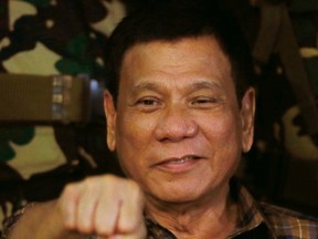 In this Aug. 25, 2016, file photo, Philippine President Rodrigo Duterte gestures with a fist bump during his visit to the Philippine Army's Camp Mateo Capinpin at Tanay township, Rizal province east of Manila, Philippines. (AP Photo/Bullit Marquez, File)