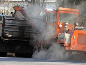 A city crew cleaning up the winters leftovers of sand emptying it into a dump truck in Edmonton in 2014. Photo by Ed Kaiser